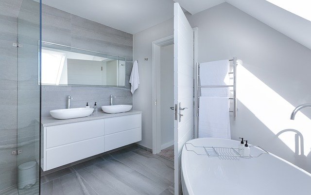 all white bathroom, double sinks, bathtub, open door